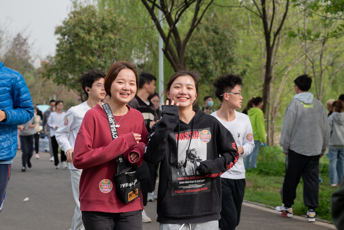 两名女生微笑着跑过沿湖东路（学通社记者 王晗藓 摄）_副本